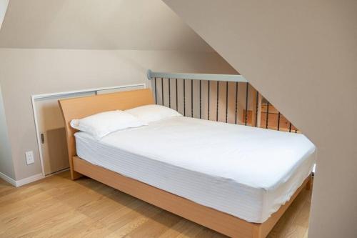 a bedroom with a bed with white sheets at itotoi本邸 in Itoshima