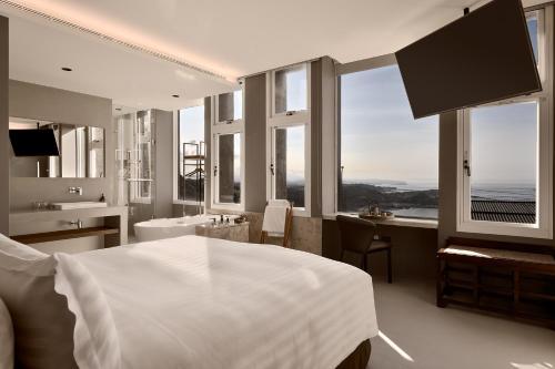 sypialnia z łóżkiem oraz łazienka z oknami w obiekcie Daybreak w mieście Jiufen