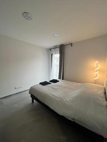 Schlafzimmer mit einem großen weißen Bett und einem Fenster in der Unterkunft Villa Les Vieux Chênes in Vacqueyras