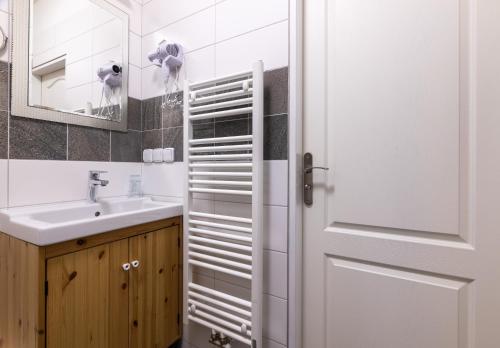 uma casa de banho com um lavatório e uma porta branca em Penzion Rodos - Café em Praga