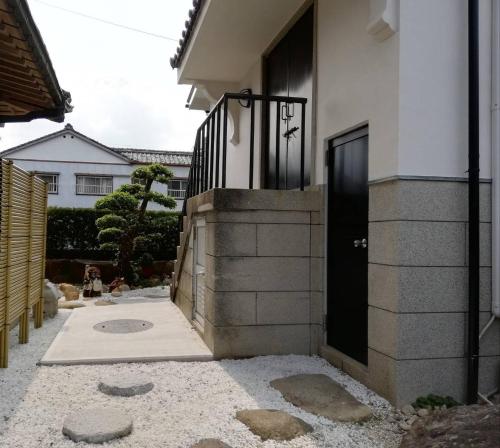 a house with a black door and a walkway at くまの蔵inn Warehouse in Shingu