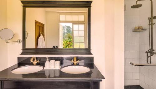 a bathroom with two sinks and a mirror at Mandira Craig Appin by HPL in Hatton
