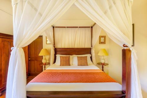 a bedroom with a canopy bed with two lamps at Mandira Craig Appin by HPL in Hatton