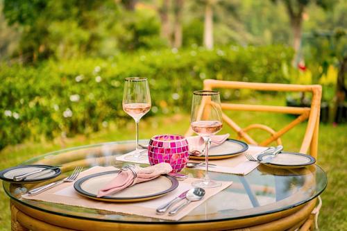 a glass table with glasses of wine on it at Mandira Craig Appin by HPL in Hatton