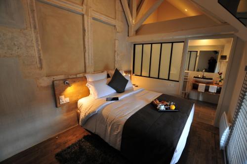 um quarto com uma cama grande e uma bandeja de comida. em SY-la terrasse em Vézelay