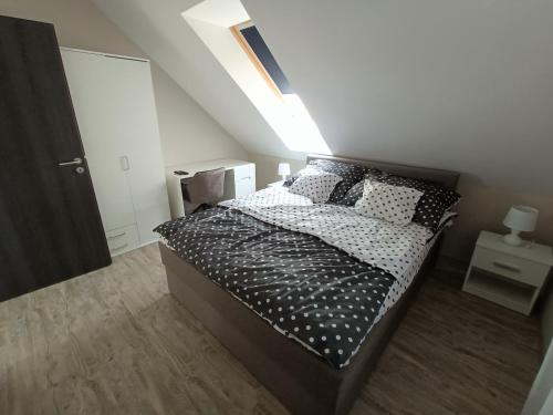 Schlafzimmer mit einem Bett mit schwarzen und weißen Kissen in der Unterkunft Flower Apartman 5 