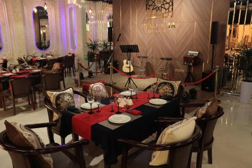 a dining room with a table and chairs and a guitar at Euro Asia Hotel in Samarkand