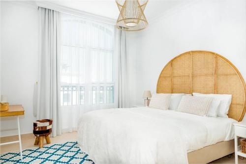 a white bedroom with a large bed and a window at Luxurious 4 bed apartment on Yas Island, Abu Dhabi in Abu Dhabi
