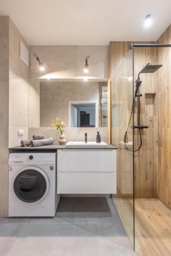 a bathroom with a washing machine and a sink at Warsaw-Aparts Sokratesa in Warsaw