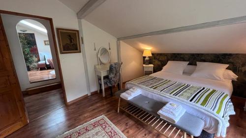 L'Ermitage de Meyriat في Brénod: غرفة نوم بسرير كبير ومرآة