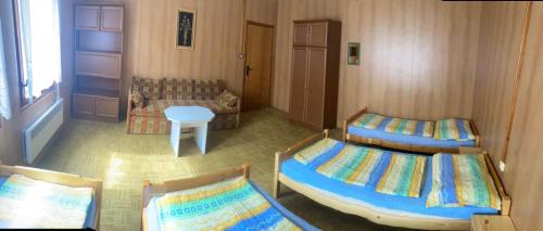 a bedroom with two beds and a table and a window at Chata CONDI in Buchlovice