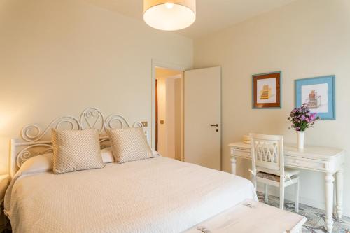 Un dormitorio con una cama blanca y un escritorio. en Sassi Scritti - Abete Bianco, en Montefegatesi