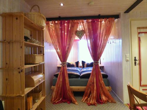 um quarto com uma cama com cortinas e uma janela em Inselromantik Rügen em Dreschvitz