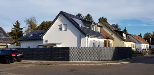 a white house with solar panels on top of a fence at Joanna Apartment - MA Casterfeld Haus in Mannheim