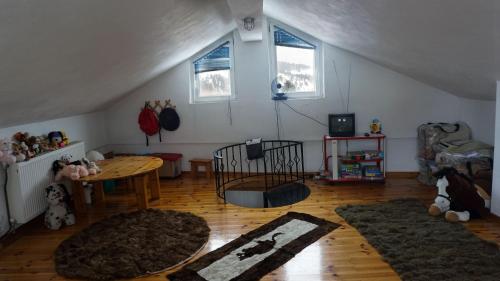 ein Wohnzimmer mit einem Tisch und 2 Fenstern in der Unterkunft Ginî Viñis in Samarína