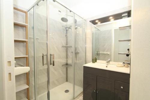 La salle de bains est pourvue d'une douche en verre et d'un lavabo. dans l'établissement Studio 2 personnes a 100m de la plage, à Canet
