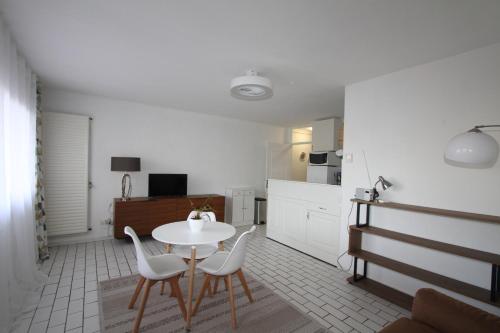 - une cuisine avec une table et des chaises blanches dans la chambre dans l'établissement Studio 2 personnes a 100m de la plage, à Canet
