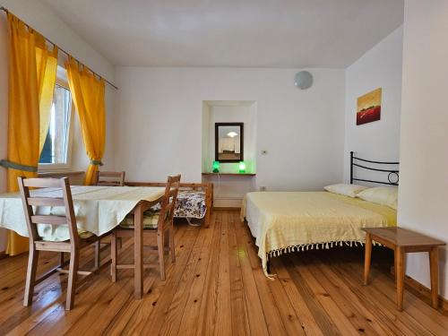 1 dormitorio con 2 camas, mesa y sillas en Apartments La Pergola, en Rovinj