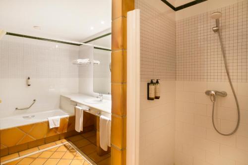 a bathroom with a tub and a sink and a shower at Ibersol Almuñecar Beach & Spa Hotel in Almuñécar