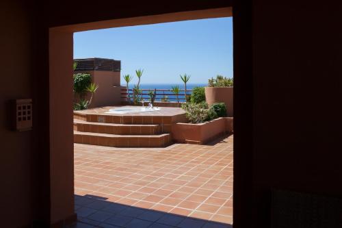 an open door to a patio with a view of the ocean at Ibersol Almuñecar Beach & Spa Hotel in Almuñécar
