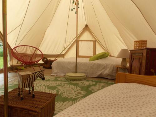 une pièce avec une tente avec un lit et un zèbre dedans dans l'établissement Camping du Petit Gué du Roi, à Cléry-Saint-André