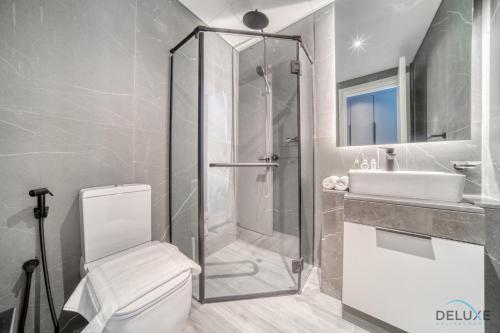 a bathroom with a shower and a toilet and a sink at Suave 2BR with Assistant Room at Mesk 1 Midtown Dubai Production City by Deluxe Holiday Homes in Dubai