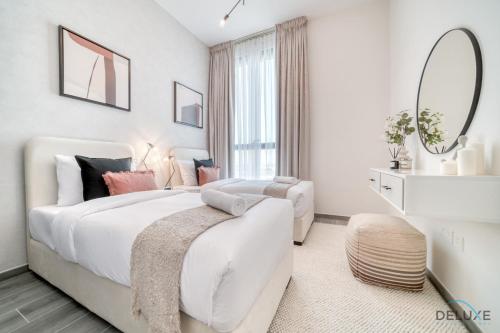 a white bedroom with a large bed and a window at Suave 2BR with Assistant Room at Mesk 1 Midtown Dubai Production City by Deluxe Holiday Homes in Dubai