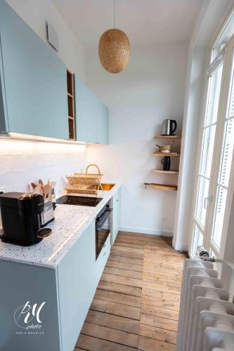 une cuisine avec une cuisinière et un comptoir dans l'établissement Le petit Balzac T2 - Hypercentre Angoulême, à Angoulême