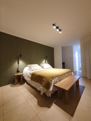 a bedroom with a large bed and a wooden bench at Premium appart LOCADOR Nueva Cordoba14C in Cordoba