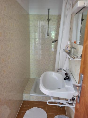 a bathroom with a sink and a bath tub at Gästehaus Rosl in Reifnitz