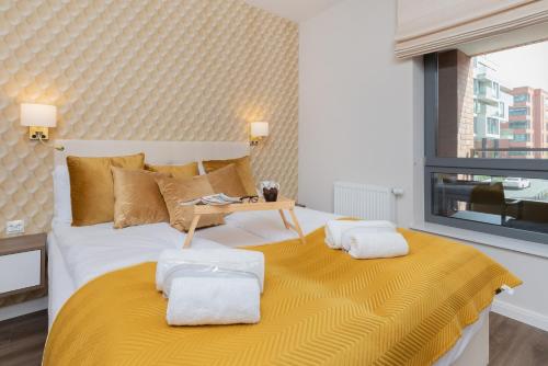 a bedroom with a large bed with a yellow blanket at Stunning Apartment with Parking in Gdansk Lower Town by Renters in Gdańsk
