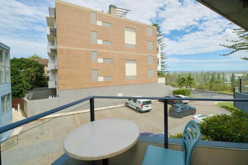 a balcony with a white table and a building at ibis Styles Port Macquarie in Port Macquarie