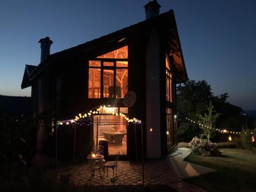 Una casa con luces de Navidad encendidas por la noche en Large Luxury Chalet in Raduil, nr Borovets - hot tub, views, Wi-Fi en Raduil