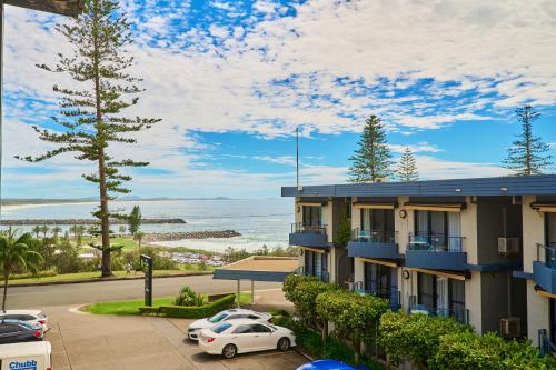 a building with cars parked in a parking lot at ibis Styles Port Macquarie in Port Macquarie
