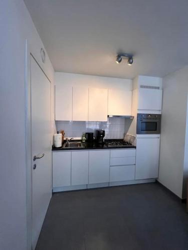 a white kitchen with white cabinets and a stove at brugsken, Sint-Niklaas in Sint-Niklaas