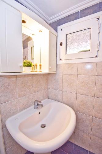 a bathroom with a sink and a mirror at Mike's apartments in Agios Gordios