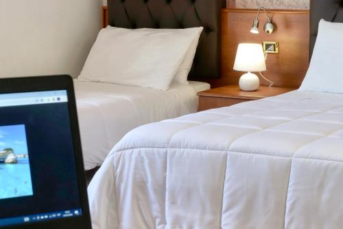 a hotel room with two beds and a computer monitor at Bed&Belvedere in Otranto