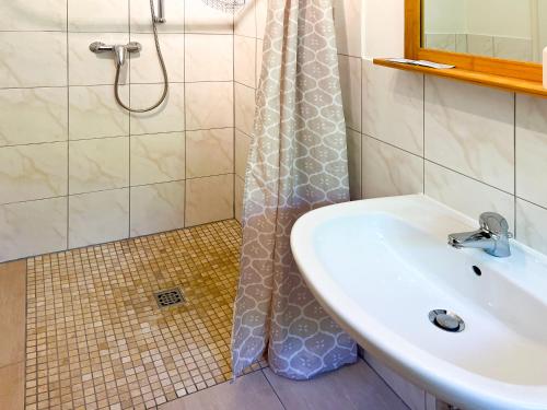 ein Bad mit einem Waschbecken und einer Dusche in der Unterkunft Himmelreich Rügen in Zirkow