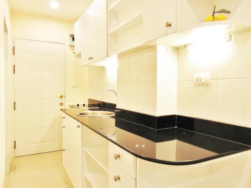 a kitchen with white cabinets and a sink at Sea View Beachfront Condos Pattaya Jomtien Beach in Jomtien Beach