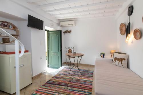 a room with a green door and a table at Chora 5 - Central Rooms by TinosHost in Tinos Town