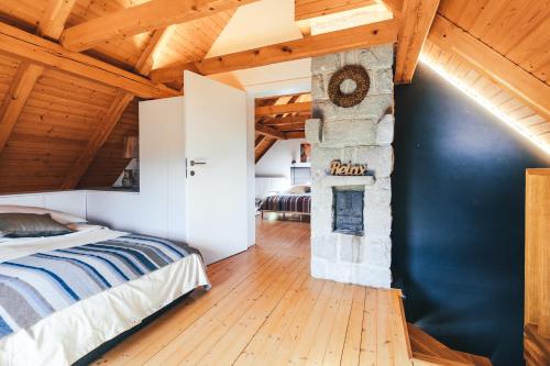 um quarto com uma cama e uma lareira de pedra em Private Lake House Selce 