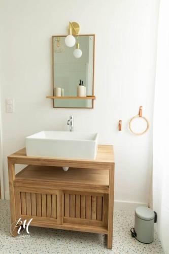 une salle de bain avec un lavabo et un miroir dans l'établissement Les pierres blanches : T2 - Hypercentre Angoulême, à Angoulême