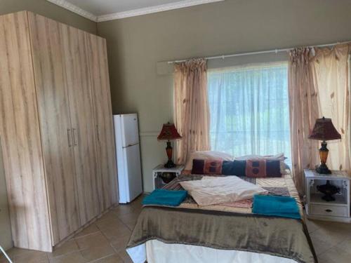 a bedroom with a large bed and a large window at Apartment 3 Magaliesberg in Brits
