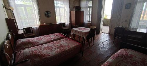 a bedroom with a bed and a table and chairs at Gia's Home in Vazisubani in Vazisubani