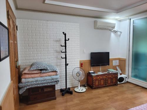 a bedroom with a bed and a tv in a room at JNW MINBAK in Damyang