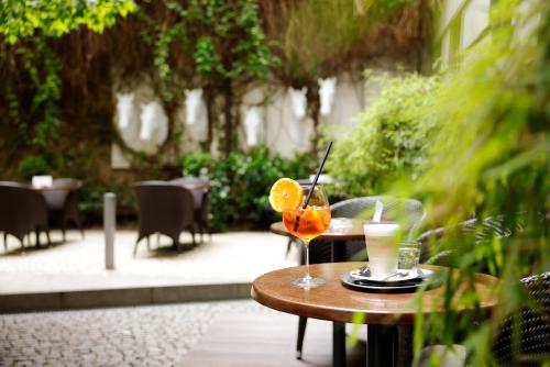 a table with a drink and a lemon slice on it at Hotel Prokop Square in Prague