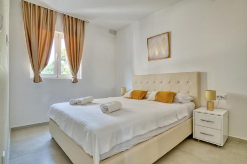 sypialnia z dużym białym łóżkiem i oknem w obiekcie The Golden Luxury complex - Central and Seaboard w Kotorze