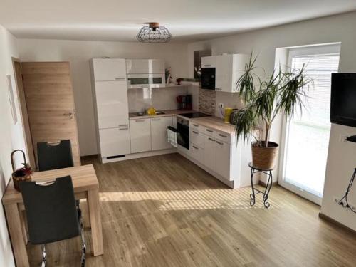 a kitchen with white cabinets and a table with a plant at Appartement Helga in Blaibach