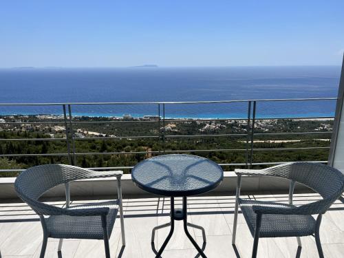 a table and chairs on a balcony with the ocean at Palasa View in Dhërmi
