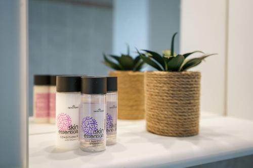 three bottles sitting on a shelf with potted plants at Alkmini Apartment in Loutra